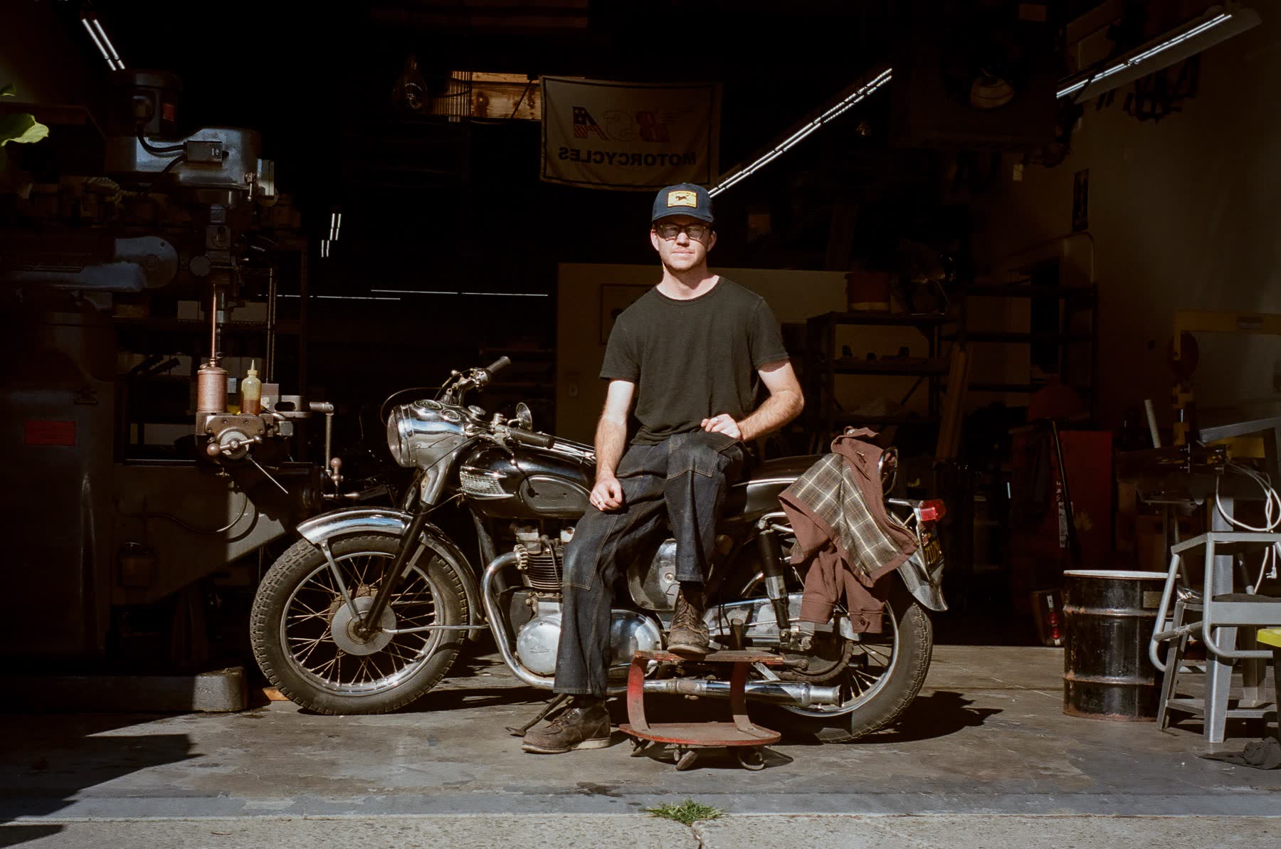 Elliot Delapre, founder of Le Hangar 23, sat on a vintage Triumph Bonneville.